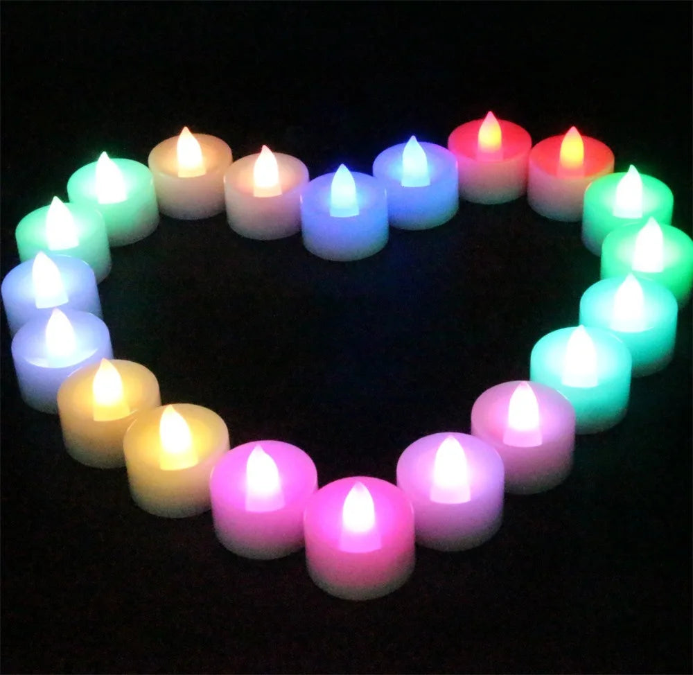 Colorful LED candles arranged in a heart shape on a black background