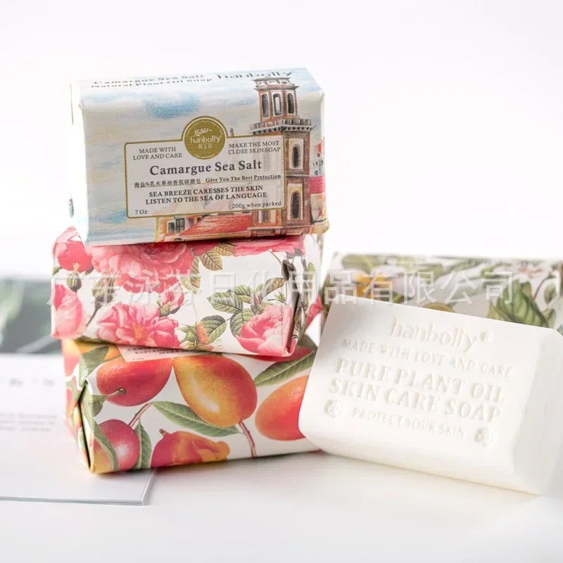 Stack of soap bars with decorative packaging on a white surface