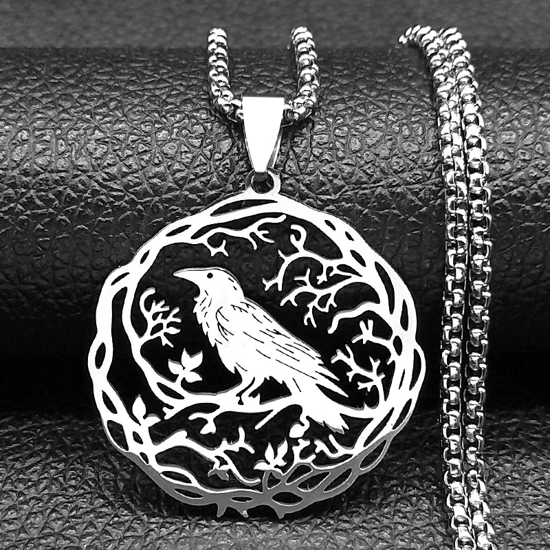 Silver pendant with bird design on a textured black surface