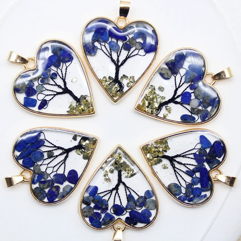 Heart-shaped pendants with tree design and blue and green elements on a white background