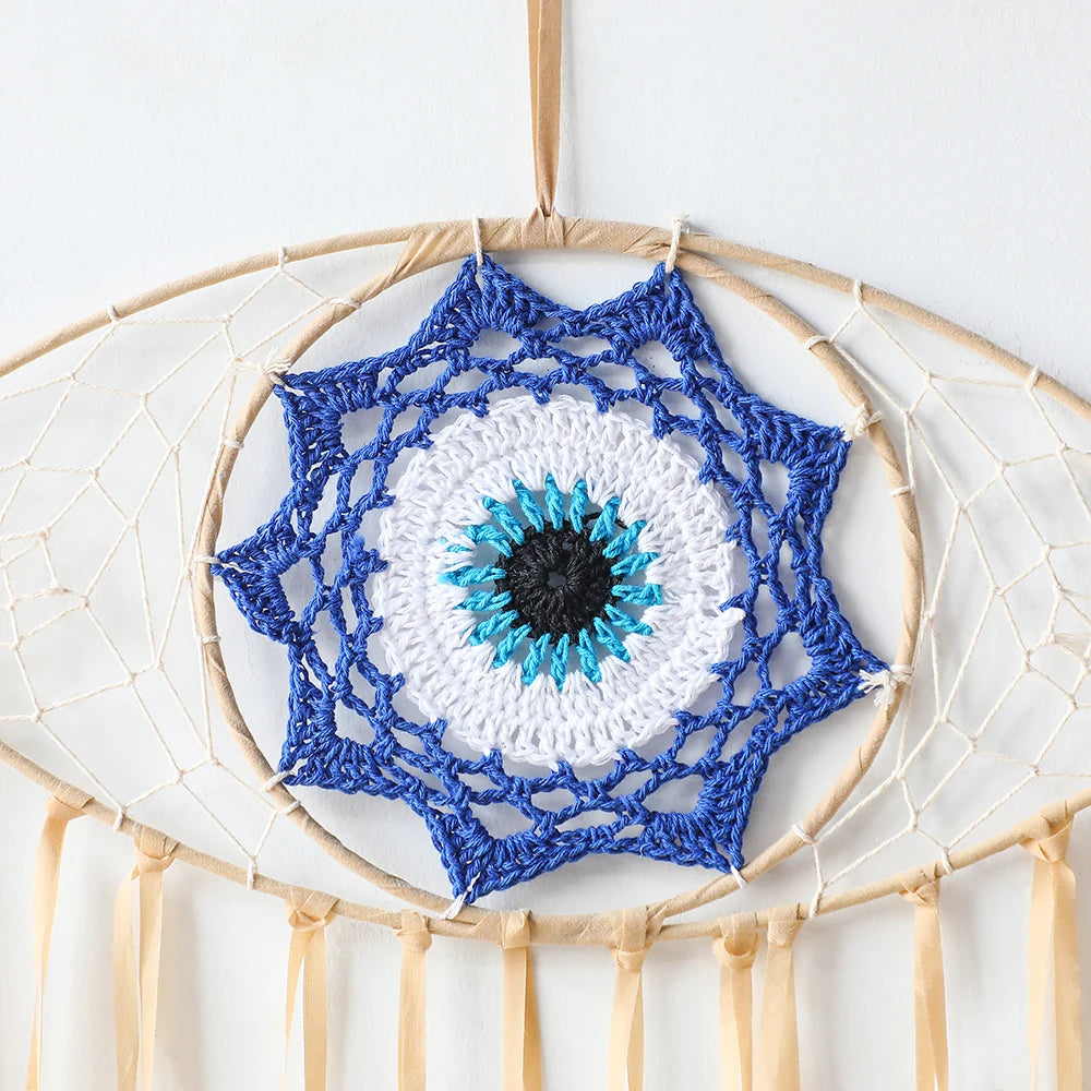 Crocheted blue and white mandala with a black center on a beige dreamcatcher.