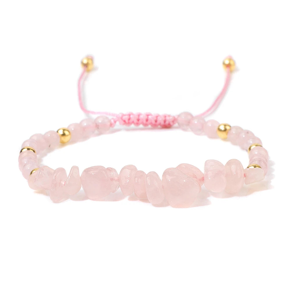 Pink beaded bracelet with gold accents on a white background