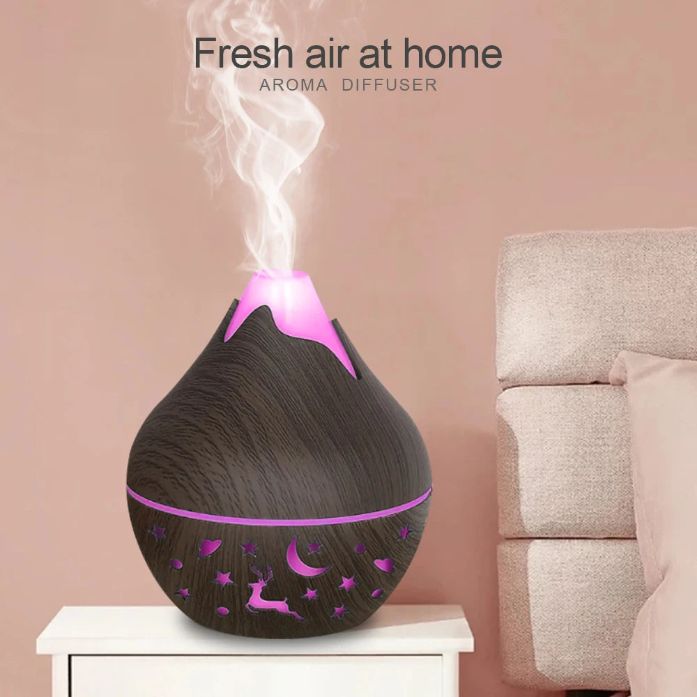 Aroma diffuser emitting steam with a pink light on a white surface against a beige wall.