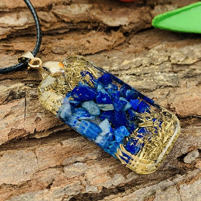 Necklace with a pendant containing blue stones and gold shavings on a wooden surface