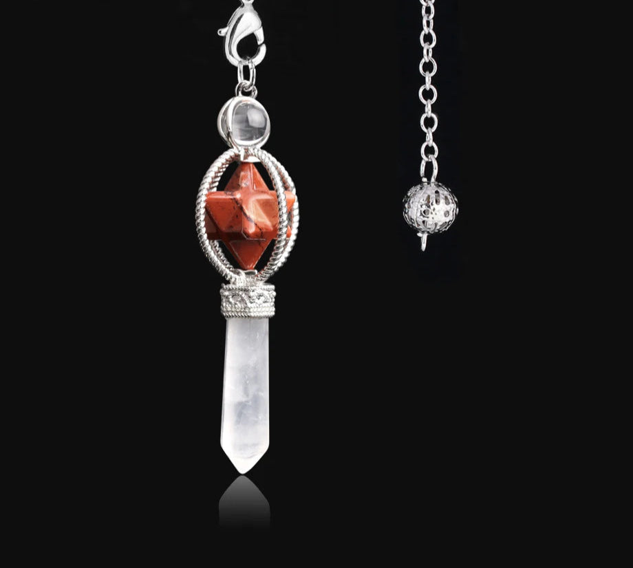 Jewelry pendant with red stone and clear crystal on a black background