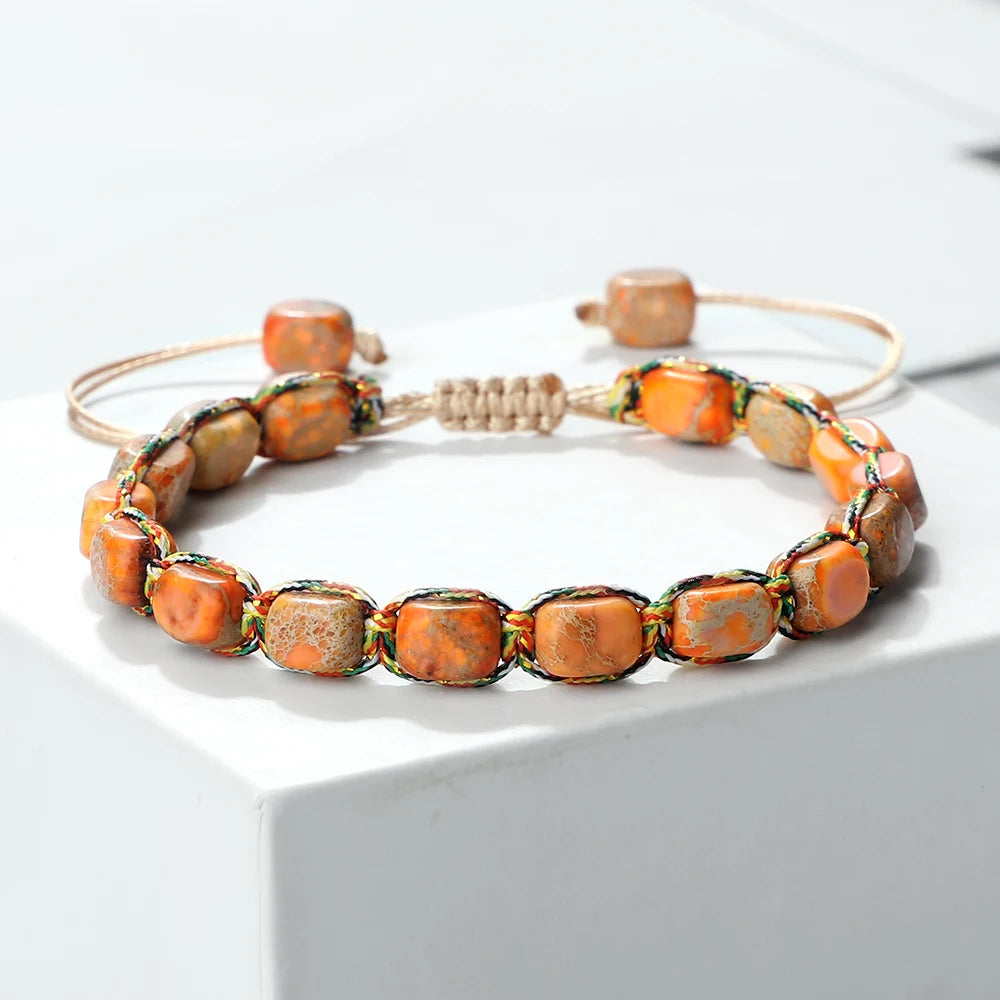 Two beaded bracelets with orange and brown beads on a white surface