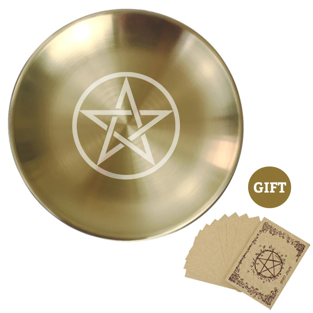 Gold dish with pentagram design and brown cards on a white background
