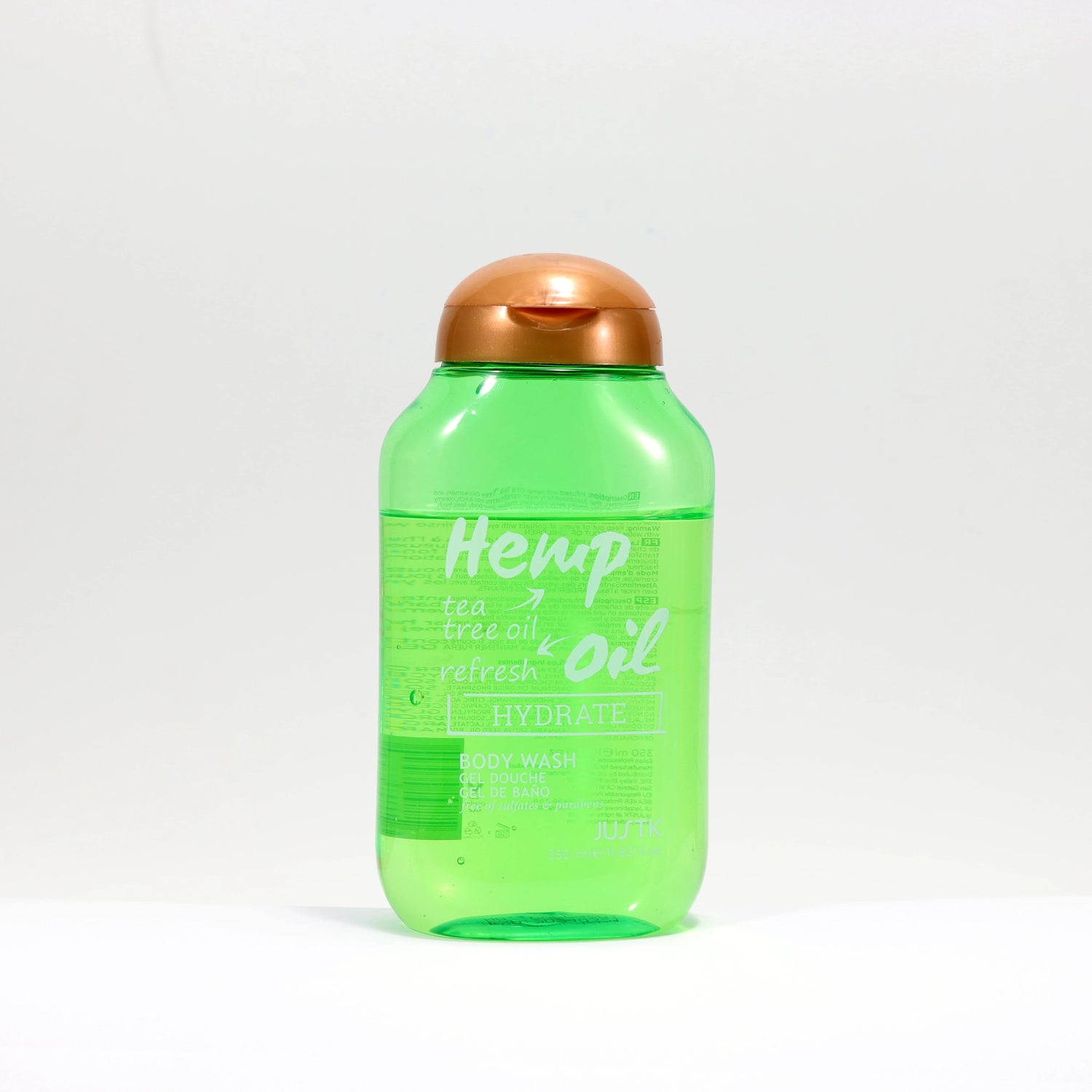 Green bottle of Hemp Tea Tree Oil with a copper cap on a white background