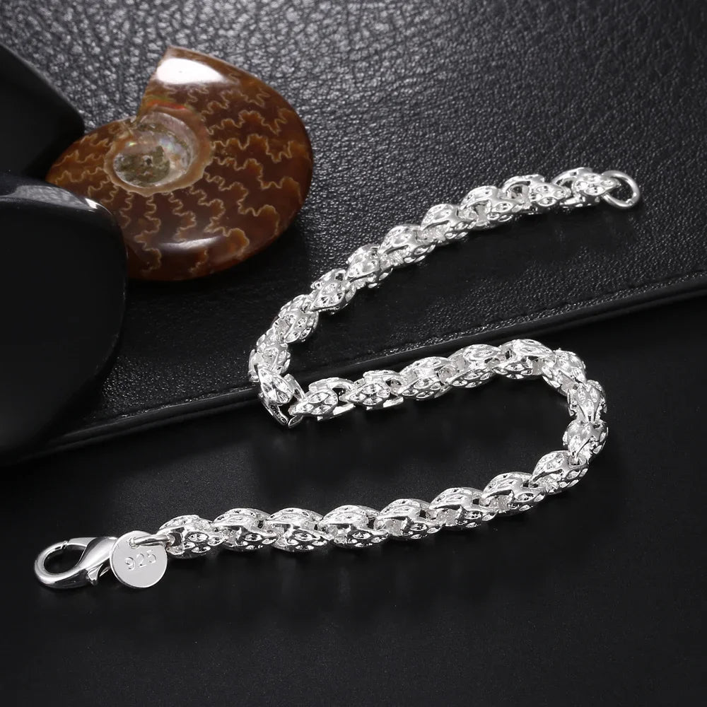 Silver chain bracelet on a dark textured surface