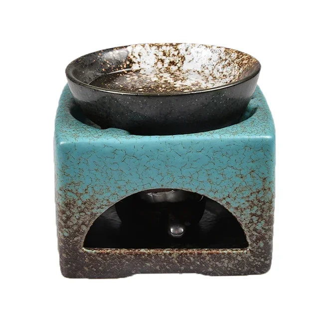Ceramic oil burner with blue base and black bowl on a white background
