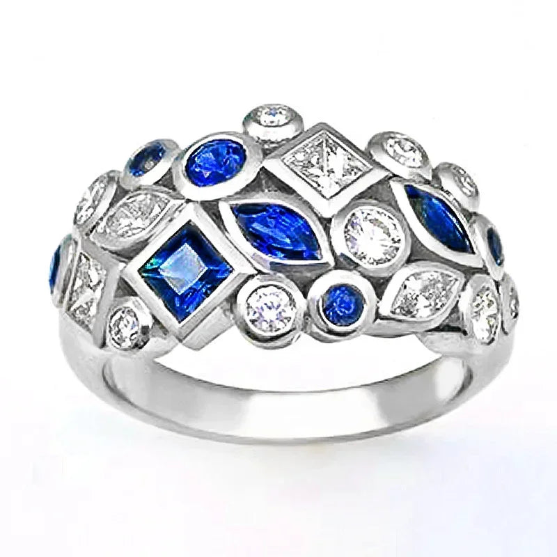 Silver ring with blue and clear gemstones on a white background