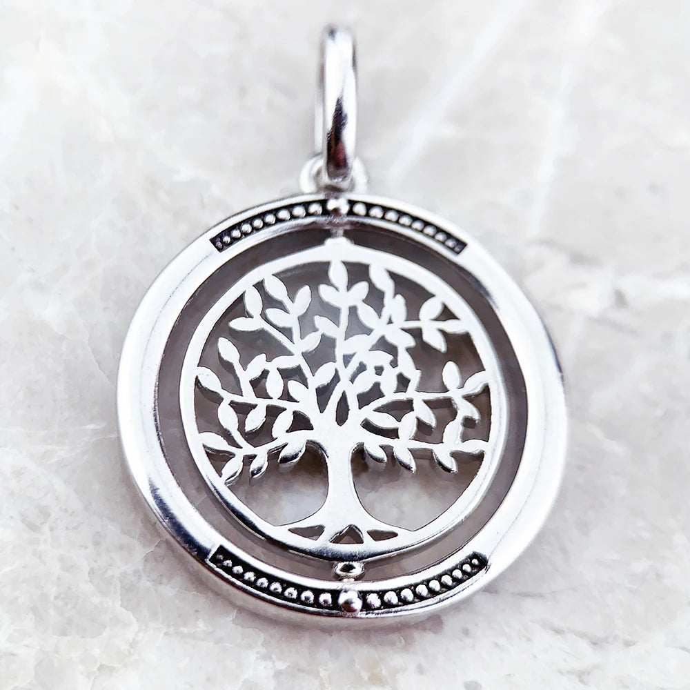 Silver tree of life pendant on a light gray background