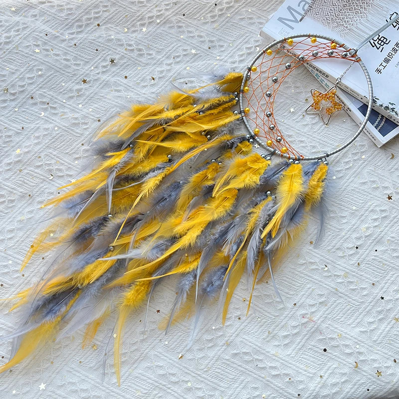 Dreamcatcher with yellow and gray feathers on a textured surface