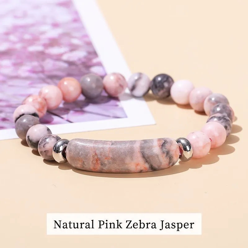 Beaded bracelet with pink and gray zebra Jasper stones on a beige background