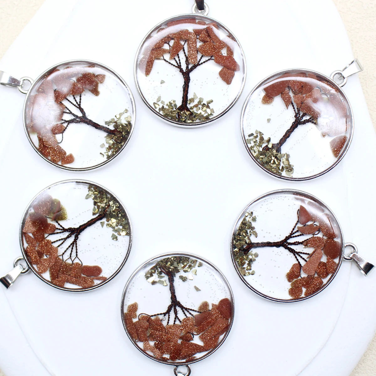 Six round tree-shaped pendants with natural elements on a white background