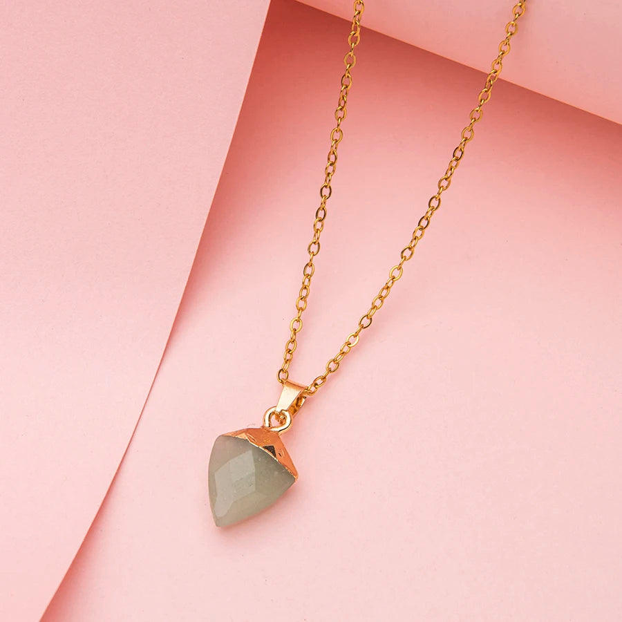 one gold necklaces with teardrop-shaped pendants on a light pink background