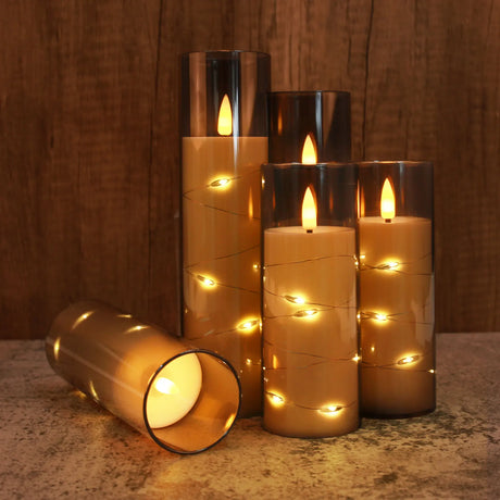 Set of decorative candles with LED lights on a wooden surface