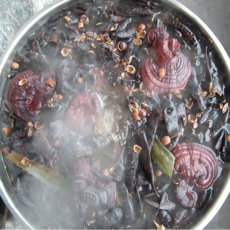 Boiling pot with mushrooms and other ingredients on a stove