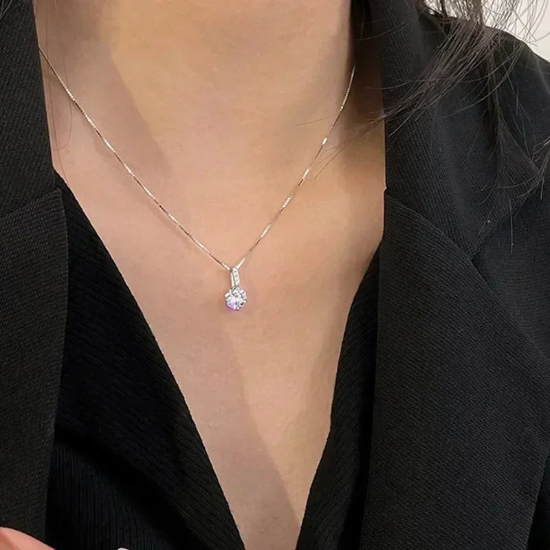 Necklace with a pendant worn by a person in a black outfit