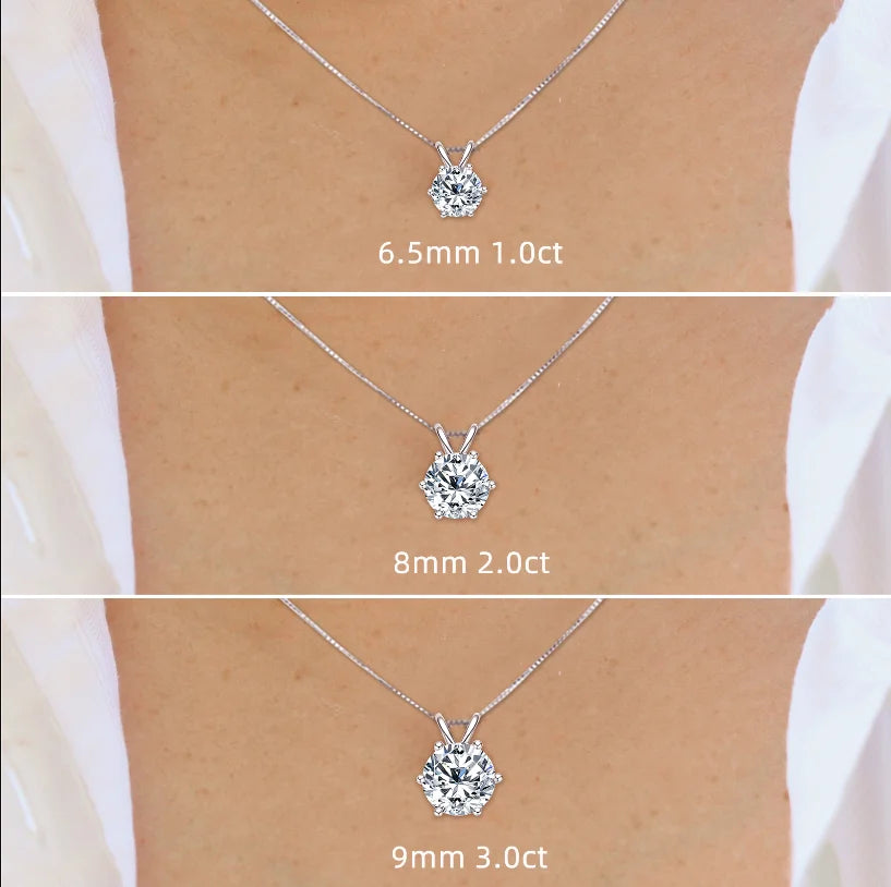 Three diamond pendants of different sizes on a person's neck.