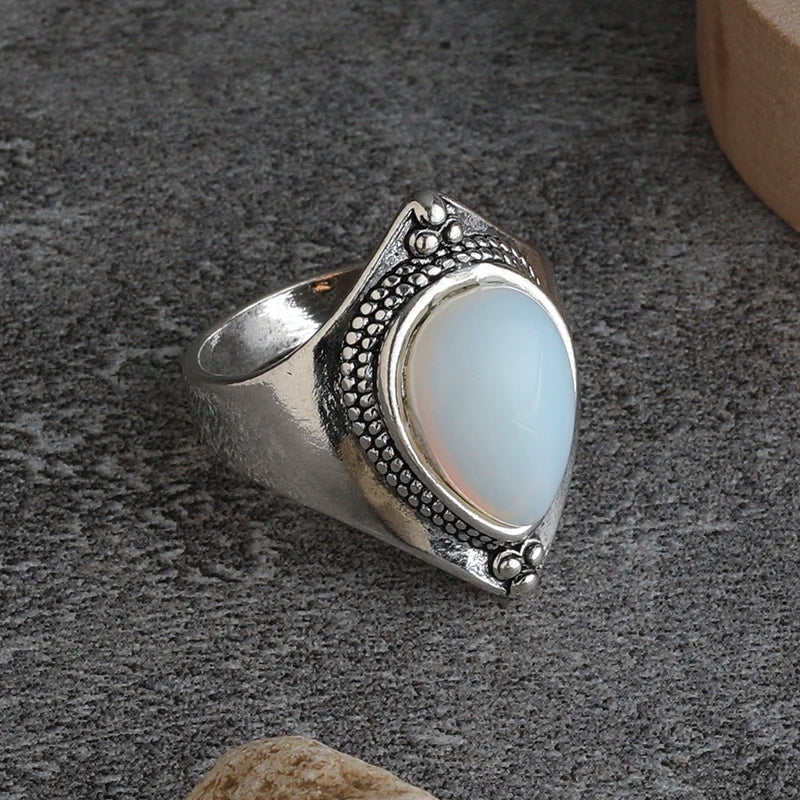 Silver ring with a teardrop-shaped stone on a gray surface