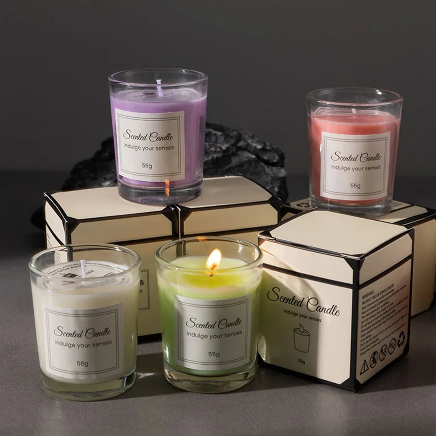 Set of scented candles with packaging on a dark surface