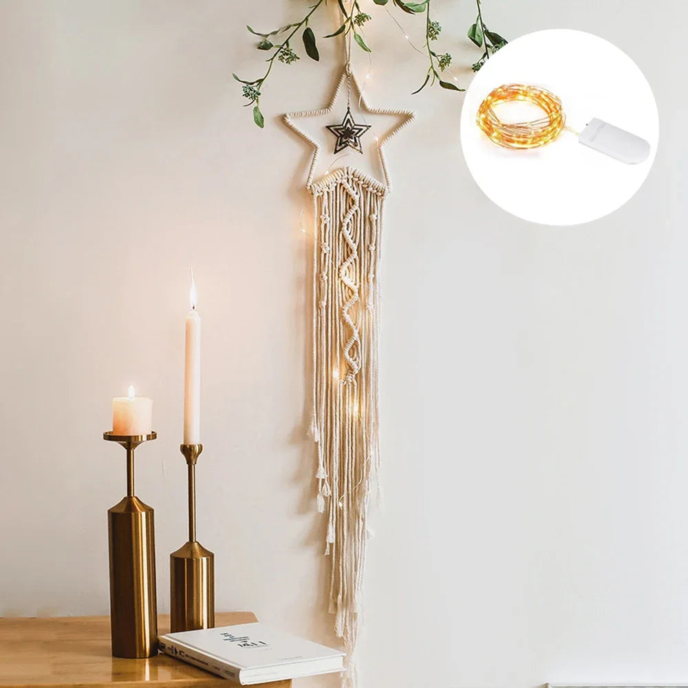 Decorative wall hanging with string lights next to candles on a table.