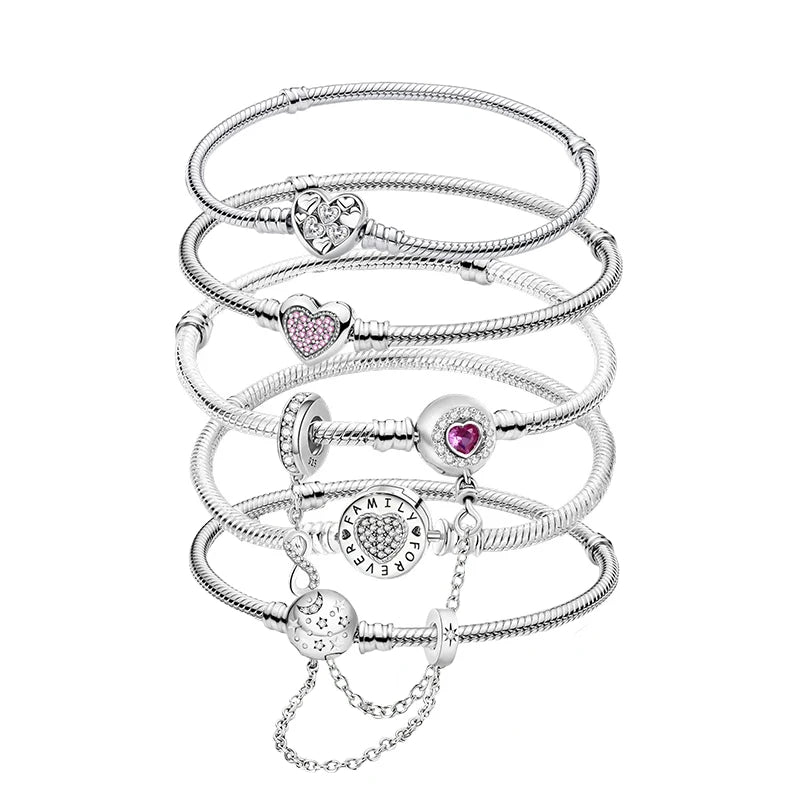 Stack of silver bracelets with heart-shaped charms on a white background