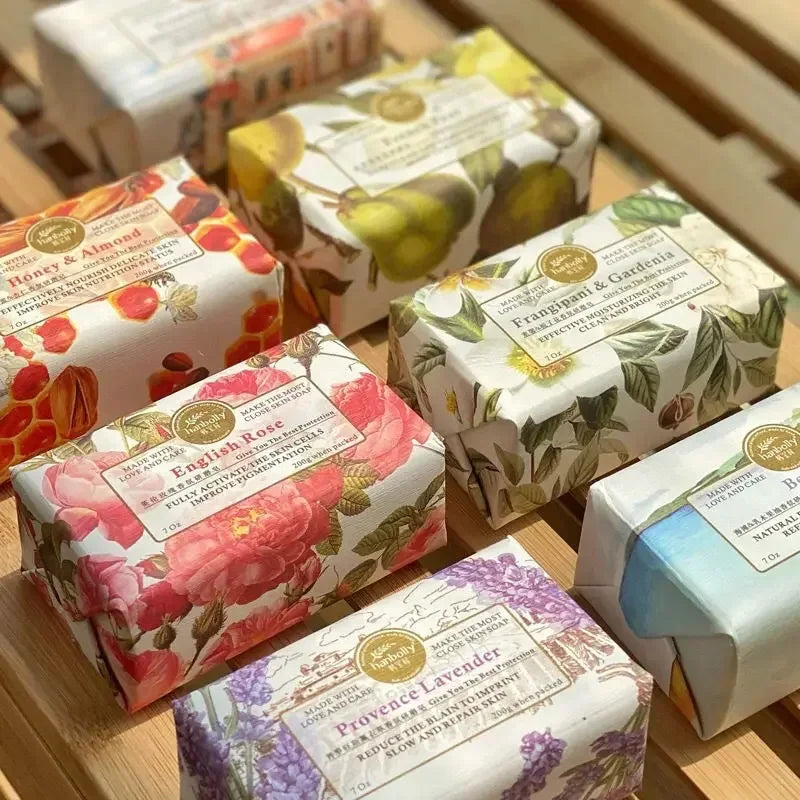 Assorted soap bars with decorative packaging on a wooden surface