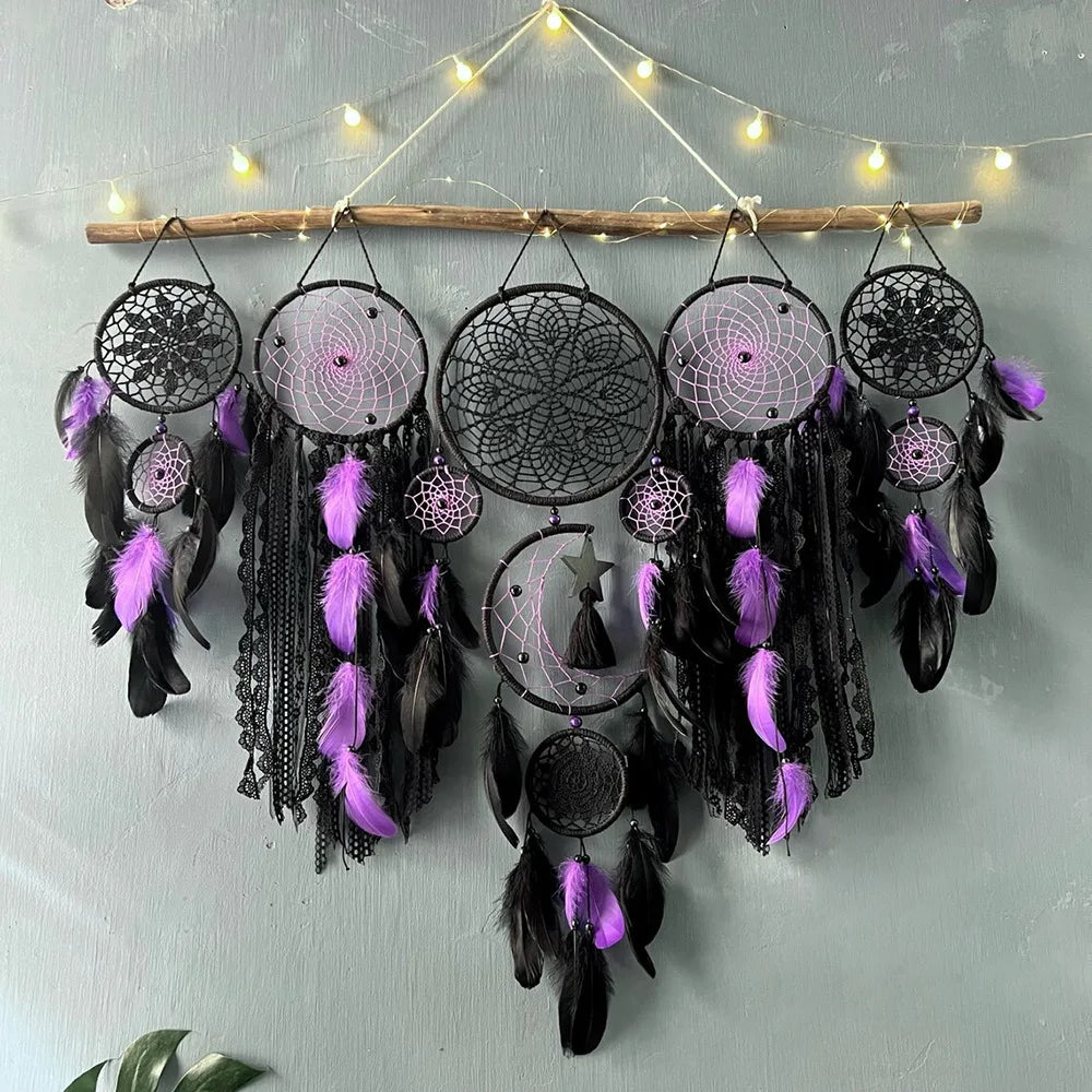 Black and purple dreamcatcher wall hanging with feathers against a light gray background.