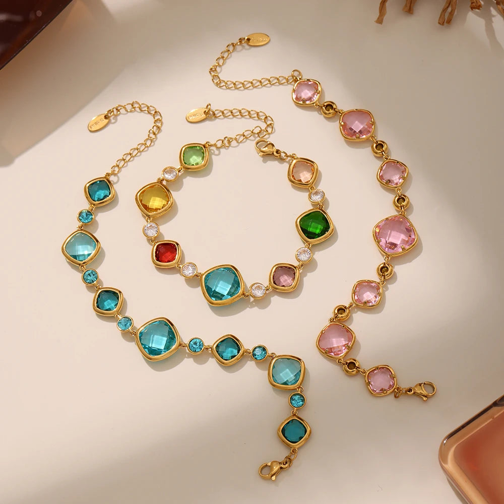 Gold necklace with colorful gemstones on a light background