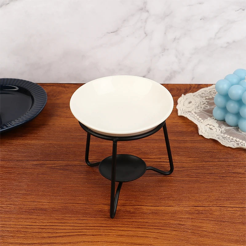 Small round table with a white ceramic top and black metal base on a wooden surface.