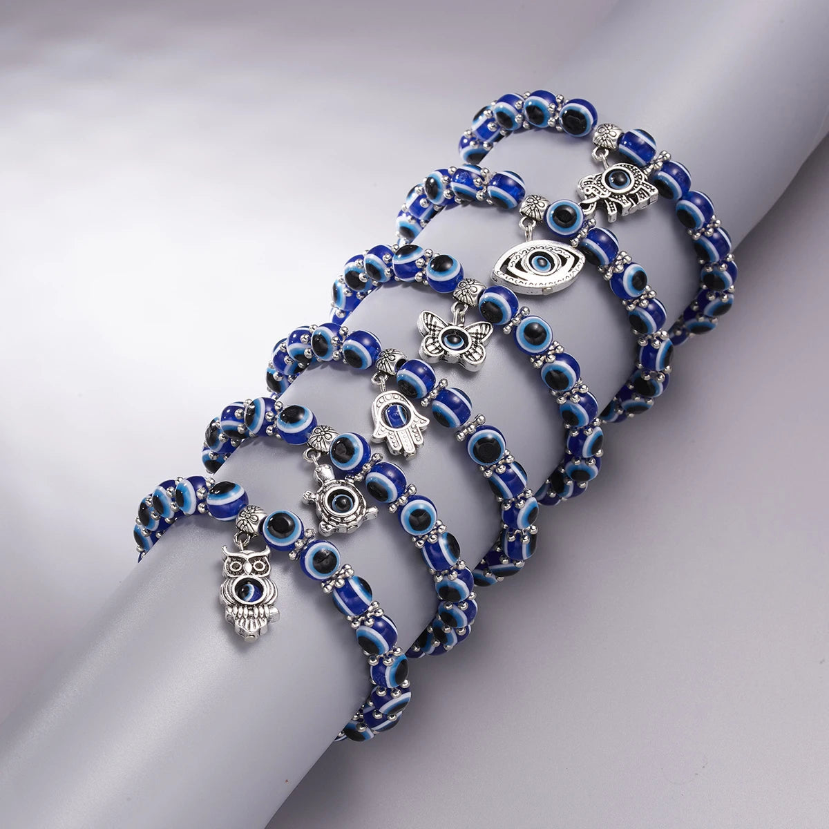 Blue beaded bracelet with silver charms on a light gray background