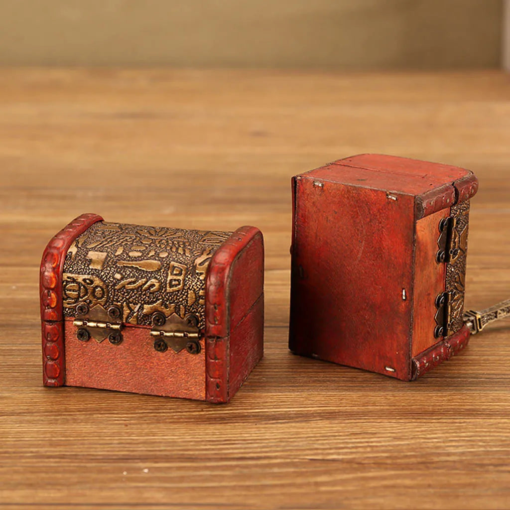 Two red wooden treasure boxes with intricate designs on a wooden surface