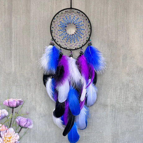 Dreamcatcher with blue, purple, and white feathers on a textured wall background