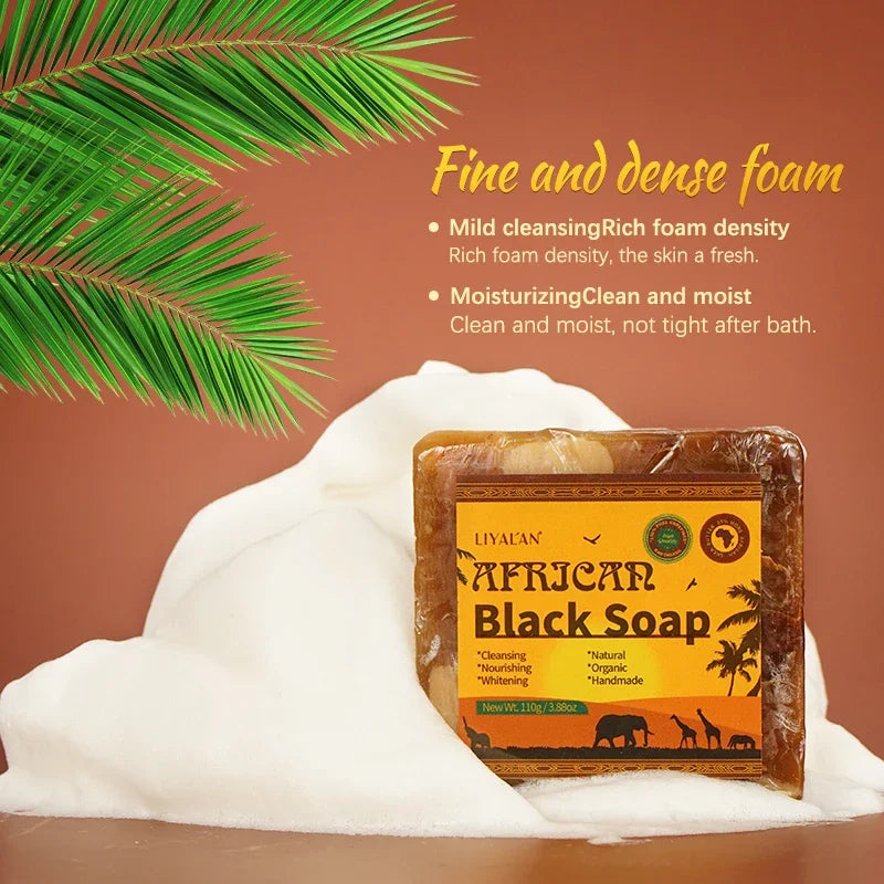 Liyaiyan African Black Soap bar with foam and palm leaf on a brown background