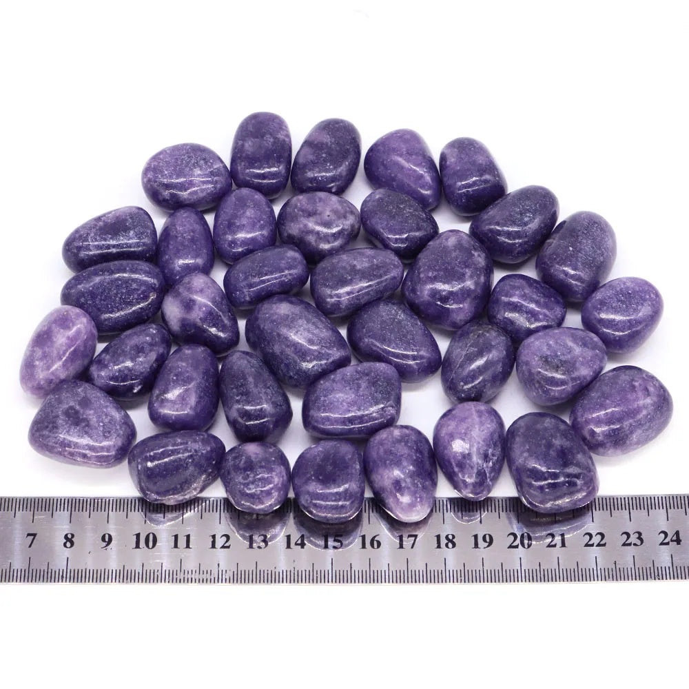 Purple stones with a ruler for size reference on a white background