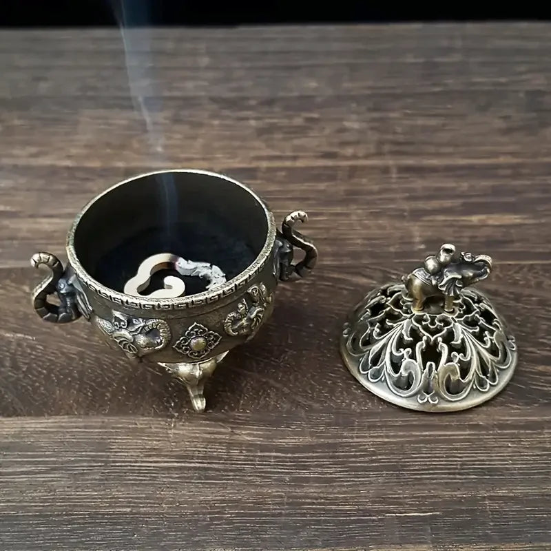 Decorative bronze incense burner with lid on a wooden surface