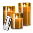 Set of three flameless candles with gold holders and a remote control on a white background