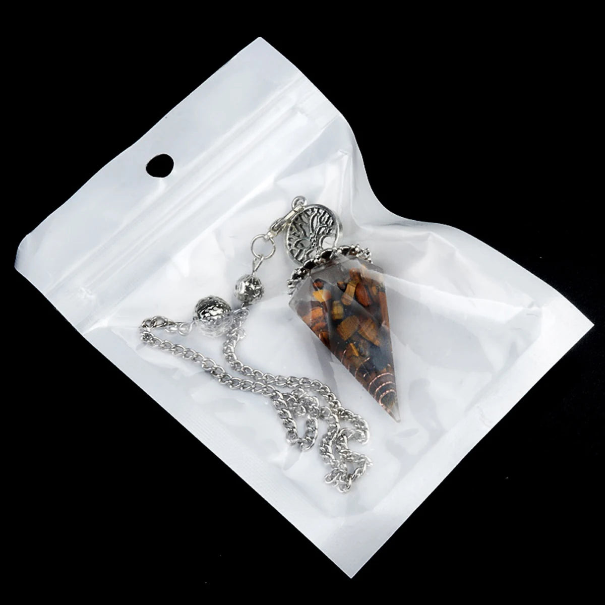 Crystal pendulum on a white card with a black background
