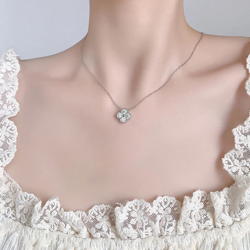 Necklace with a floral pendant on a mannequin wearing a lace dress.