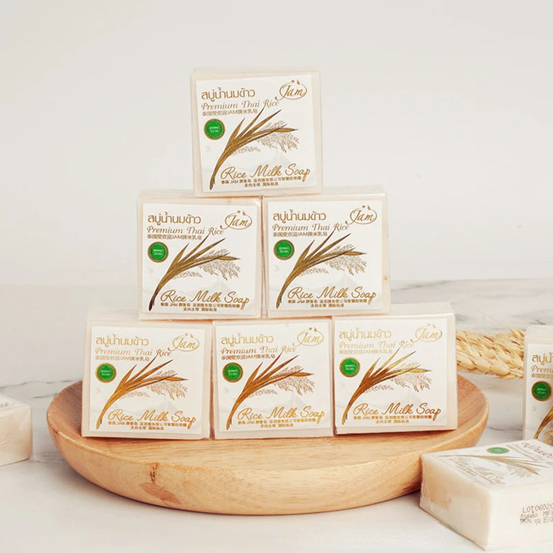 Multiple boxes of rice milk soap on a wooden tray with a white background