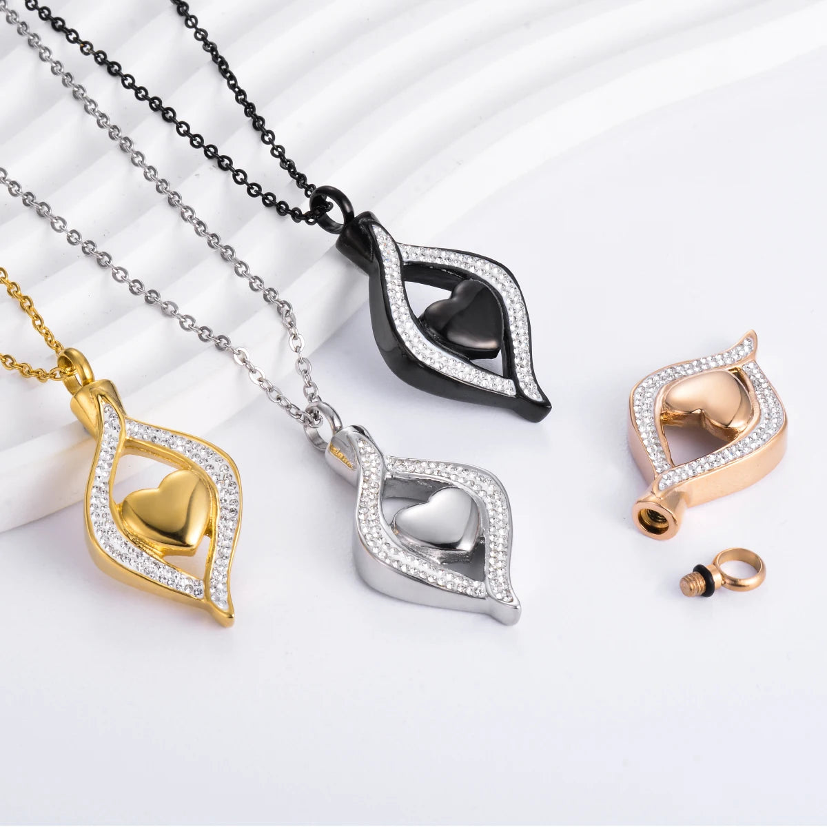 Heart-shaped pendants in gold, silver, and black on a white background