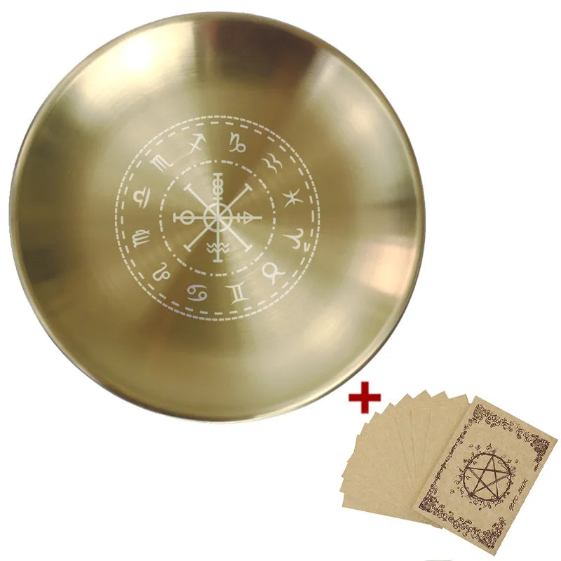 Gold plate with engraved symbols and small brown cards with similar designs on a white background