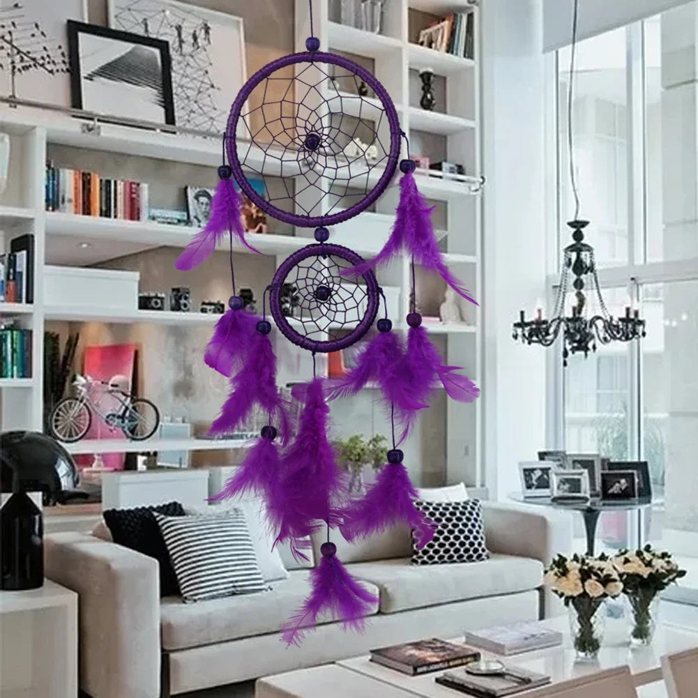 Purple dreamcatcher hanging in a living room with a bookshelf and sofa in the background.