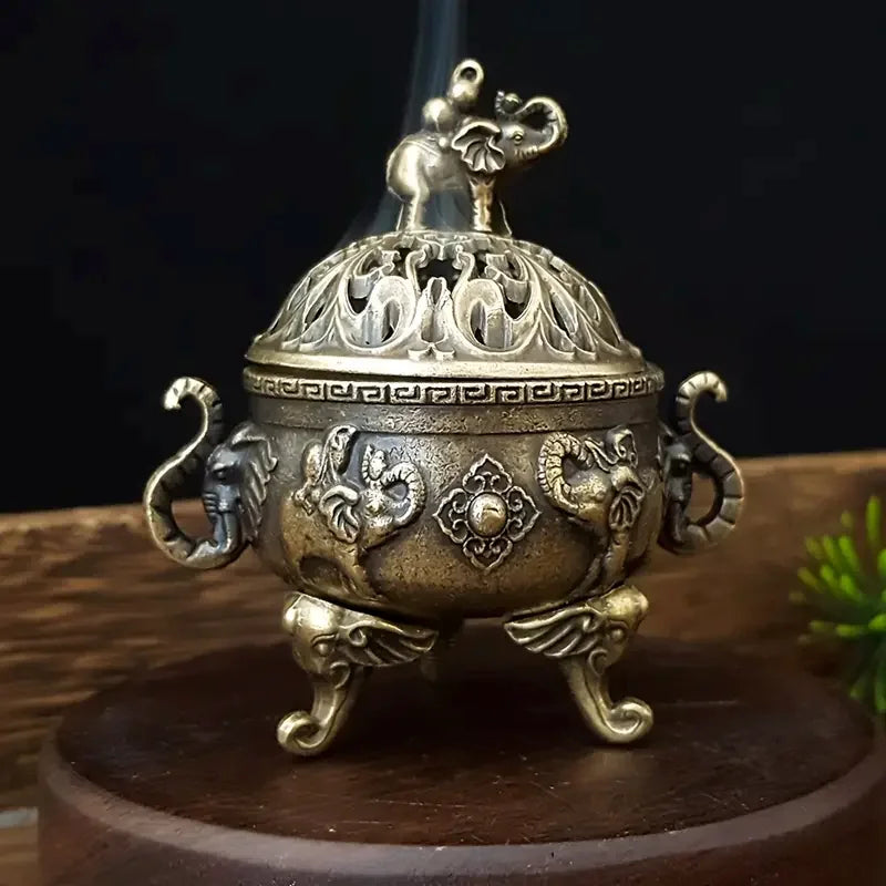 Decorative bronze incense burner with intricate designs on a dark background