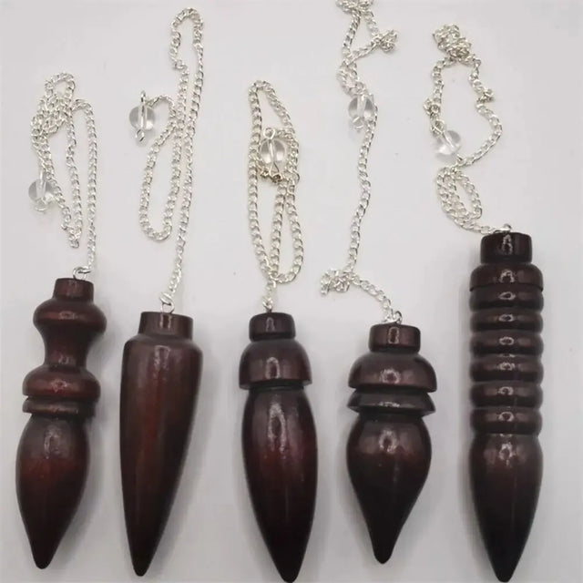 Set of five wooden pendulums on silver chains against a white background