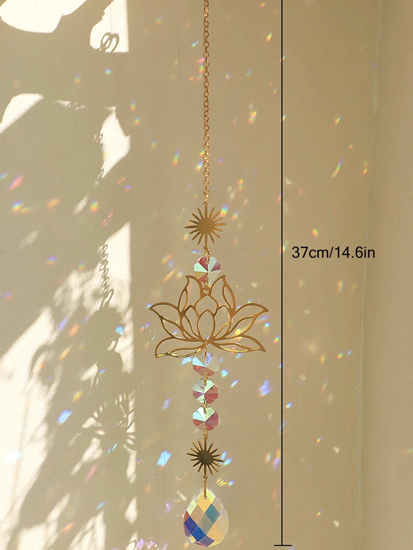 Decorative hanging crystal sun catcher with gold lotus design and colorful gemstones, against a neutral background.