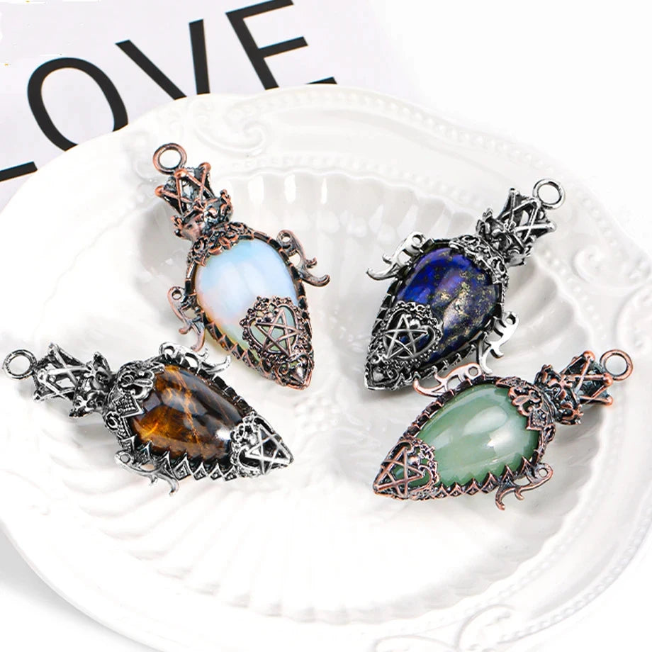 Four ornate pendants with different colored stones on a white dish.