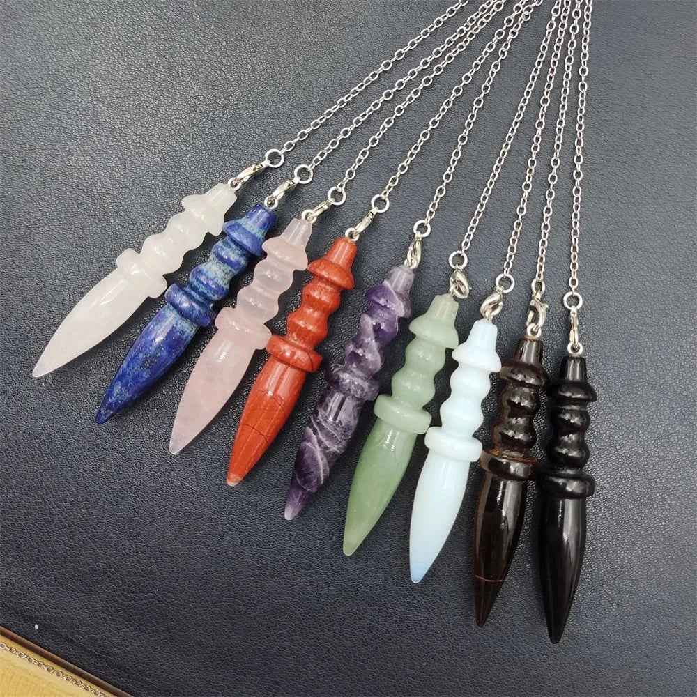 Set of colorful crystal pendants on chains against a dark background